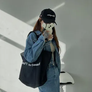 Casual black canvas shoulder bag with letter print, stylish daily student tote for women.
