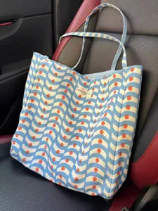 Detail shot of blue wave patterned canvas tote bag, large capacity casual daily shoulder bag.