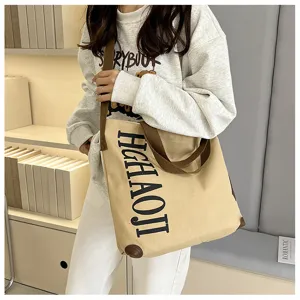 Vue détaillée du grand sac cabas en toile avec bretelles marron et lettres imprimées.