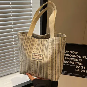Striped canvas tote bag detail, casual daily handbag with sturdy web handles for commute.