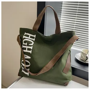 Vue détaillée du grand sac cabas en toile verte avec lanières marron et lettres élégantes.