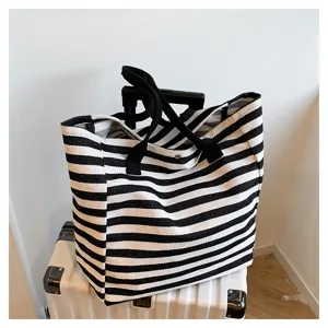 Classic black and white striped canvas tote bag detail view, spacious commuter shoulder bag.