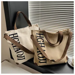 Sacs cabas en toile de grande capacite en beige et kaki avec anses marron et impression.