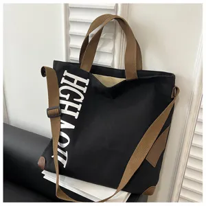 Sac cabas en toile noire décontracté avec anses marron et lettrage blanc pour usage quotidien.