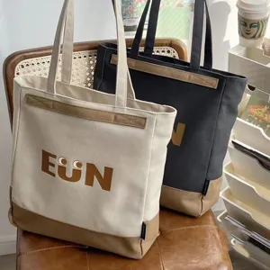 Detailed view of large canvas tote bag with contrast bottom, sturdy handles, and cute print.