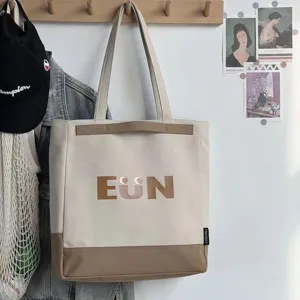 Detailed view of the casual canvas tote bag with contrast brown bottom and cute graphic print.