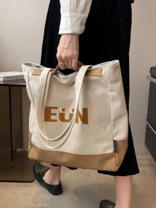Canvas tote bag detail view, casual beige and brown shoulder handbag, large daily commuter bag.