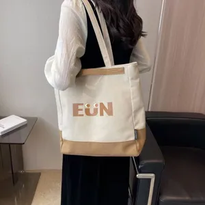 Canvas tote bag detail view, casual Korean style with cute letter print and contrast bottom.