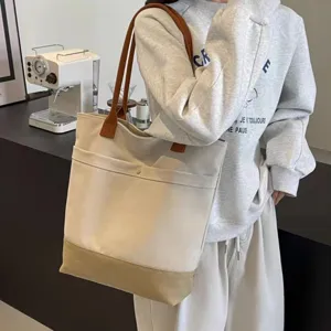 Canvas tote bag detail view, casual shoulder bag with contrast straps for daily commute.
