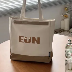Canvas tote bag detail showing cute letter print front design and spacious daily commuter structure.