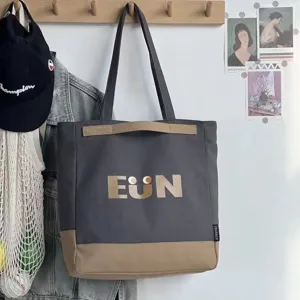 Detailed view of canvas tote bag with letter print and contrast design for daily use.