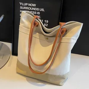 Detail view of the stylish canvas tote bag with contrast handles and spacious interior.