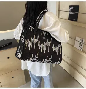 Detailed view of the stylish canvas tote bag with embroidered wave patterns and handles.