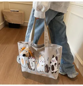 Detailed view of the casual canvas tote bag featuring cute cat prints and a plush dog charm.