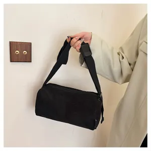 Black corduroy shoulder bag detail shot, showcasing soft fabric texture, adjustable strap and zipper.