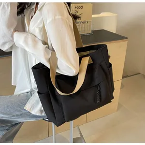 Casual black canvas tote bag with wide beige straps, large capacity shoulder bag for commuting.