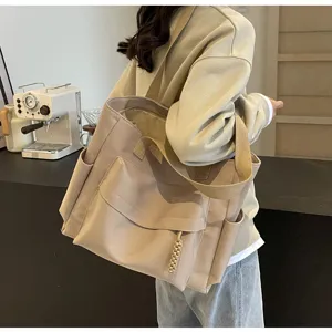Casual beige canvas tote bag with large capacity, multiple pockets and stylish design details.
