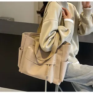 Detailed view of large canvas tote bag with side pockets and comfortable shoulder straps.