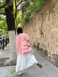 Pink canvas tote bag for women, large capacity shoulder handbag with stylish letter print.