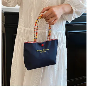 Mini sac à main bleu marine chic avec poignées perlées et broderie jolie et stylée.