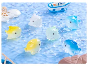 Vista dettagliata di piccole statuine di squalo luminose sfumate per decorazione acquario.