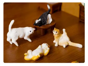 Vista dettagliata di simpatiche statuine di gatti in resina in divertenti pose da yoga.