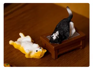 Primo piano di simpatiche statuine di gatti in resina, posa buffa per ufficio e decoro.