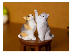 Dettaglio statuetta gatto in resina, due gattini carini su sgabello, decoro.