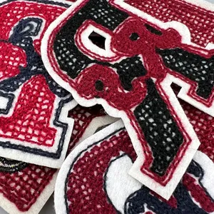 Nahaufnahme von großen Buchstaben Stickapplikationen, strukturierter Chenille Stoff für DIY Kleidung.