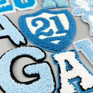 Detaillierter Blick auf blaue Chenille Stickerei Flicken, flauschige Buchstaben Nahaufnahme.