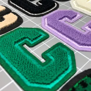 Nahaufnahme von bunten Chenille-Buchstabe-C-Stickaufnähern, ideal als Bekleidungszubehör.