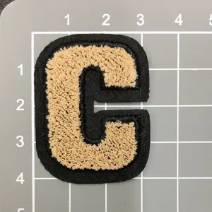 Chenille Stickerei Buchstabe C Aufnäher Detailaufnahme, schwarz-beige College Jacke Zubehör.