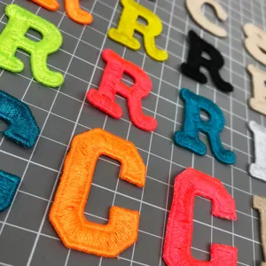 Colorful embroidered alphabet letter patches for DIY clothing hats and craft decorations.