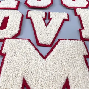 Chenille letter patch detail shot, white and red varsity alphabet embroidery for clothing.