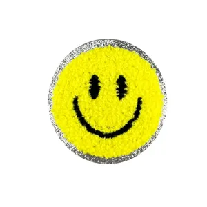 Écusson brodé éponge smiley jaune avec bordure pailletée argentée pour vêtement DIY.