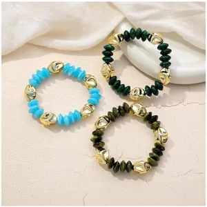 Primer plano detallado de coloridas pulseras de cuentas bohemias con cuentas doradas brillantes.