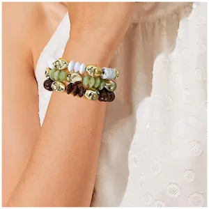 Primer plano detalle de pulsera de cuentas multicapa con detalles dorados y piedras naturales.