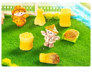 Close-up view of cute miniature scarecrow and wheat sheaf figurines for DIY garden landscaping.