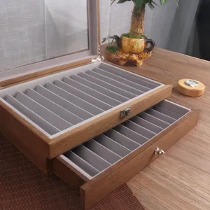 Scatola porta penne in legno vintage con coperchio in vetro e scomparti in velluto grigio.