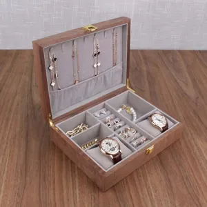 Wooden jewelry box detail showing velvet interior slots for rings, necklaces, and watches.