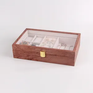 Wooden jewelry box with clear lid, ring slots and watch pillows for elegant desktop storage.