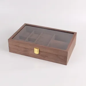 Wooden jewelry box with glass lid and storage compartments for rings and watches.