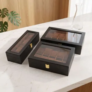 Matte black watch box set with glass window and brown velvet pillow for jewelry display.