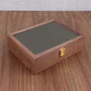 Detailed view of a black walnut wood watch and jewelry storage box with glass lid.