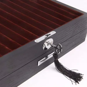 Wooden pen storage box detail showcasing velvet lining, lock, and key with tassel decoration.