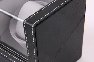 Detailed shot of black PU leather watch winder box corner with white stitching and clear lid.