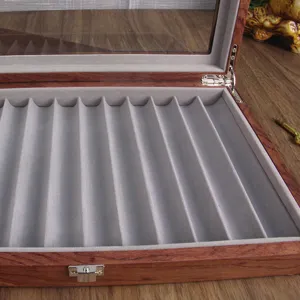 Close-up detail view of the wooden pen display box, showing interior velvet slots and metal hardware.