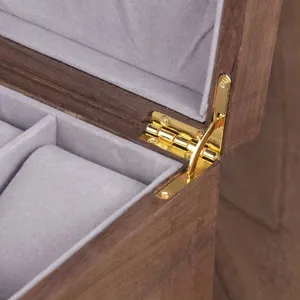 Detailed view of wooden watch box hinge, grey velvet interior lining, premium craftsmanship.