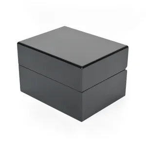 Close-up detail of the black glossy wooden watch box showing smooth piano paint finish.