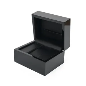 Black wooden watch box detail showing glossy piano finish and soft leather interior.